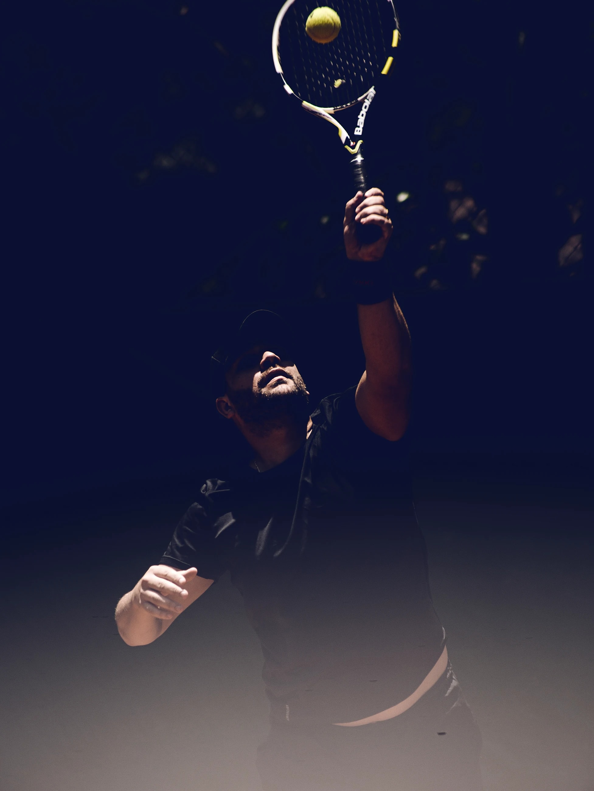 A tennis player lunging into a forehand, her movement blurred against a dark background.